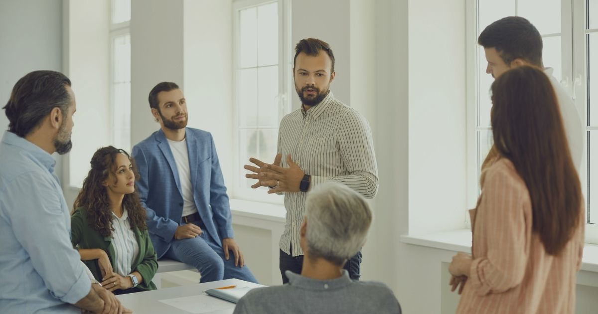 Neues Team übernehmen – neue Führungskraft spricht zum ersten Mal mit ihrem Team, das aufmerksam zuhört