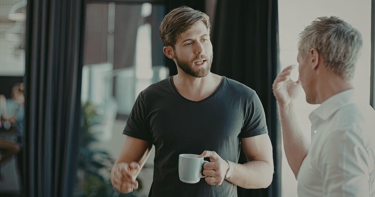 Jüngere Führungskraft im Gespräch mit einem älteren Mitarbeiter – Thema: Mitarbeiter passt nicht ins Team